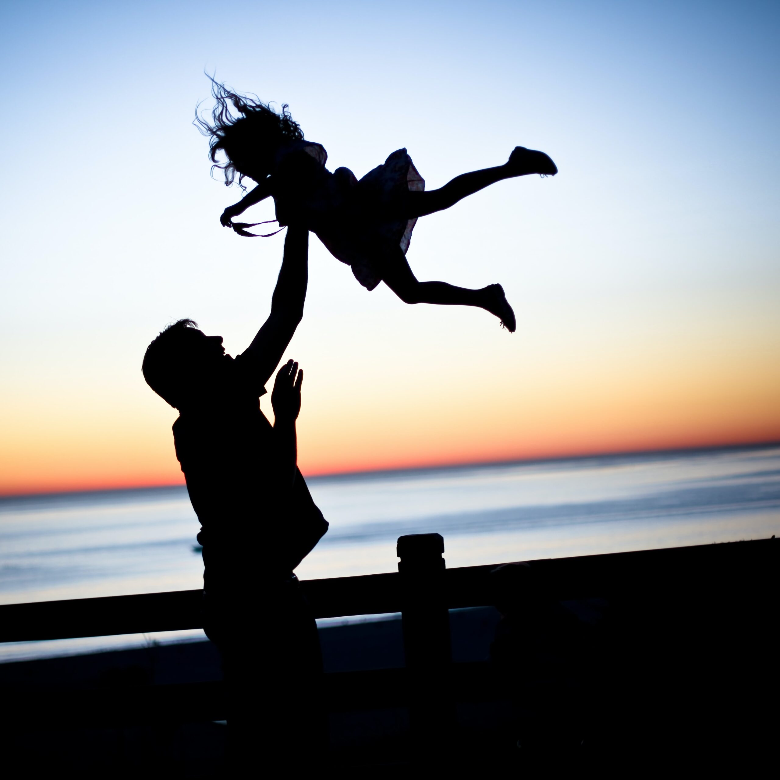 dad5 A father tossing his daughter up in the air at sunset
