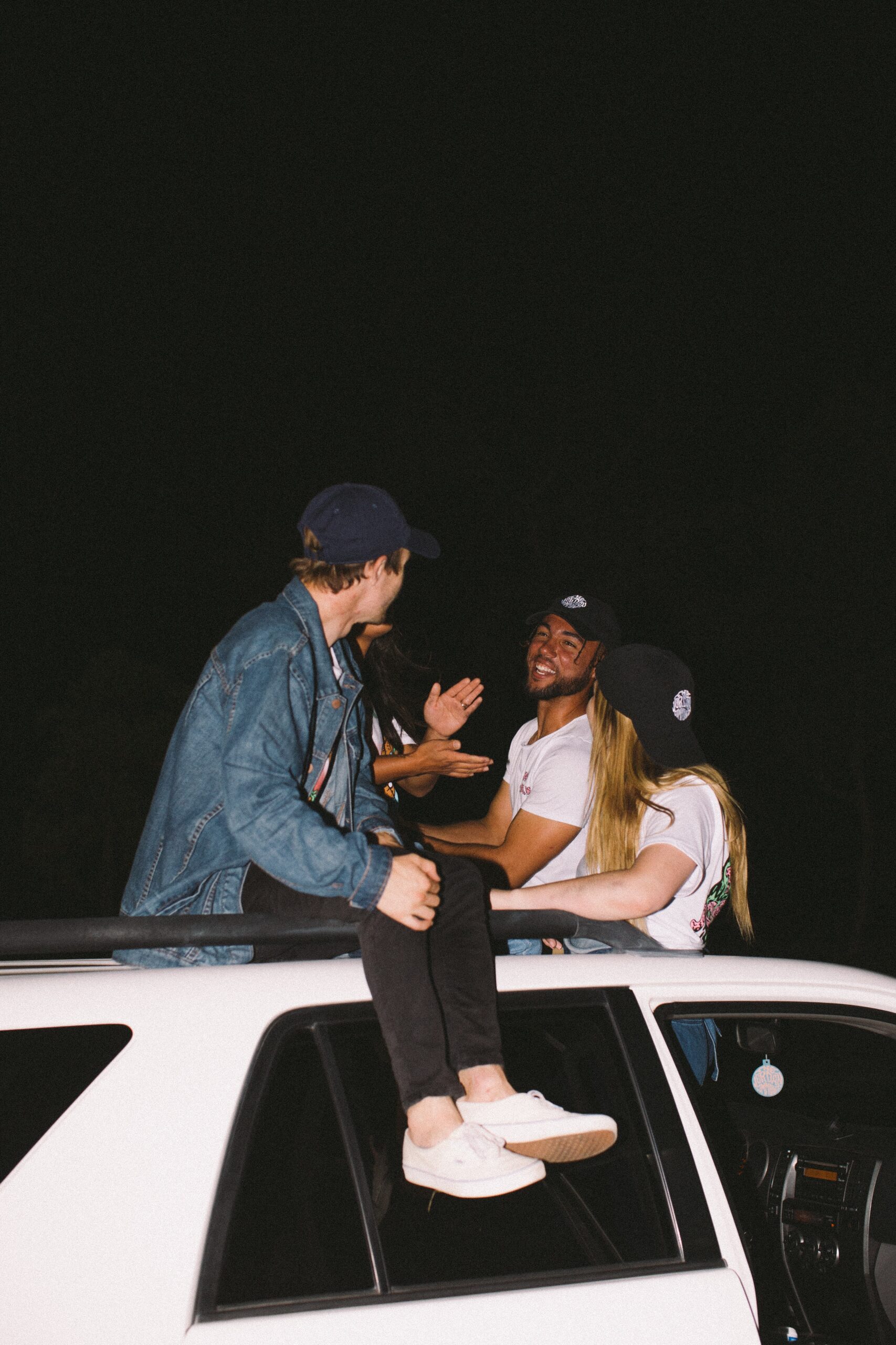 friends1 friends sitting on the roof of an SUV