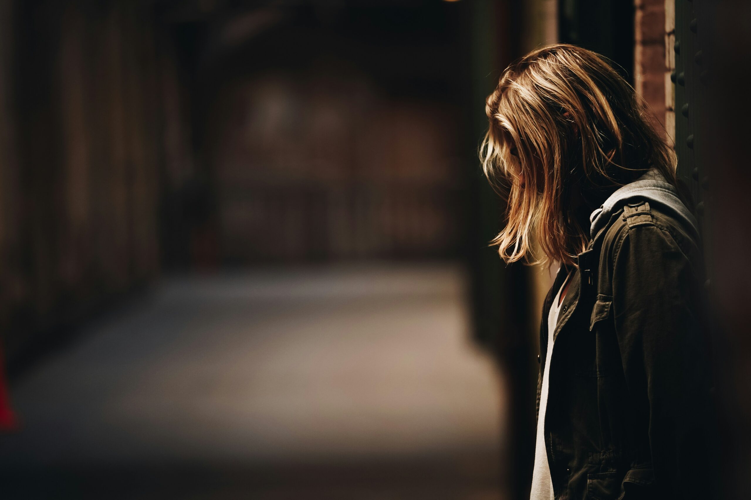 person with long hair looking downcast