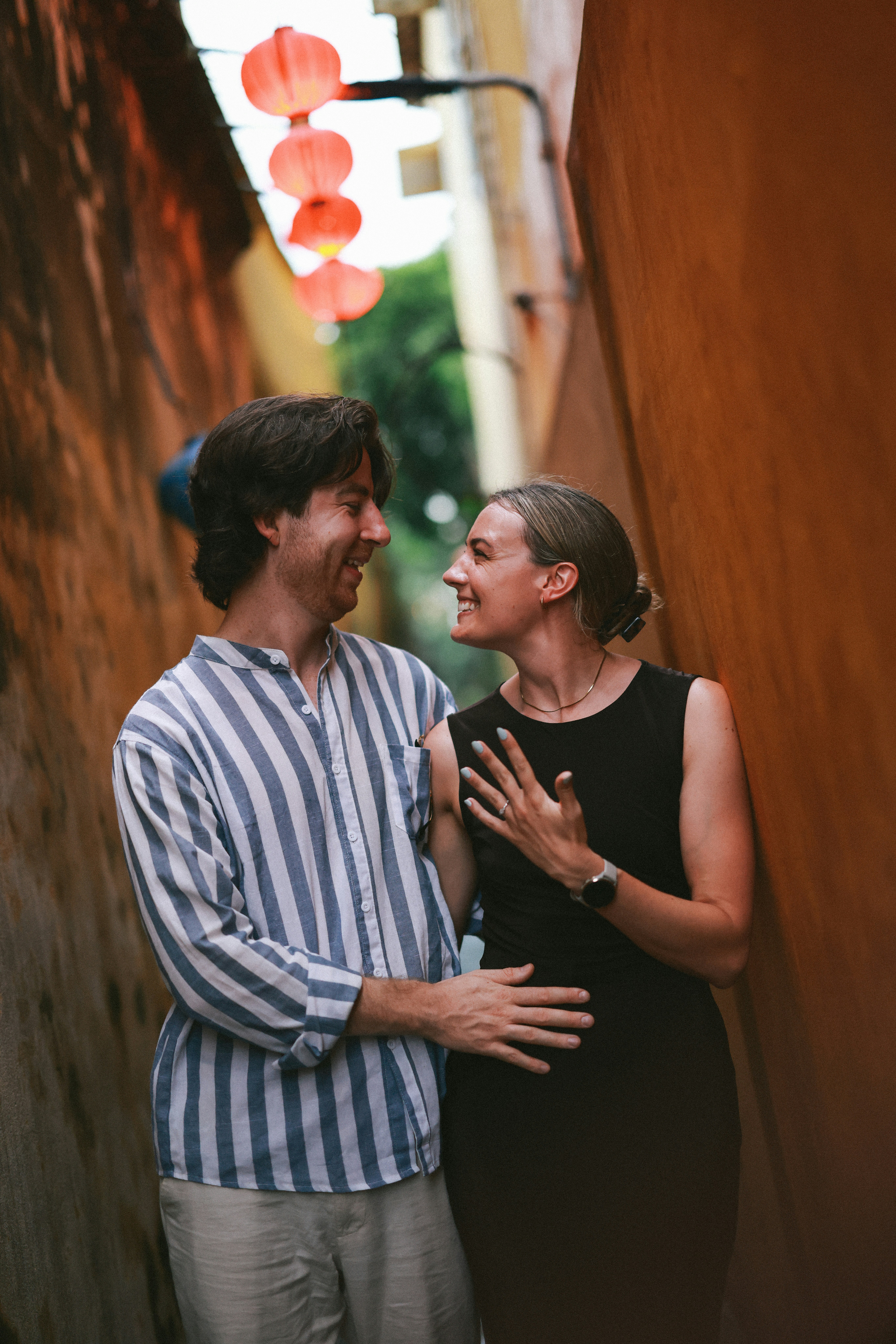 couple smiling and walking down an alley