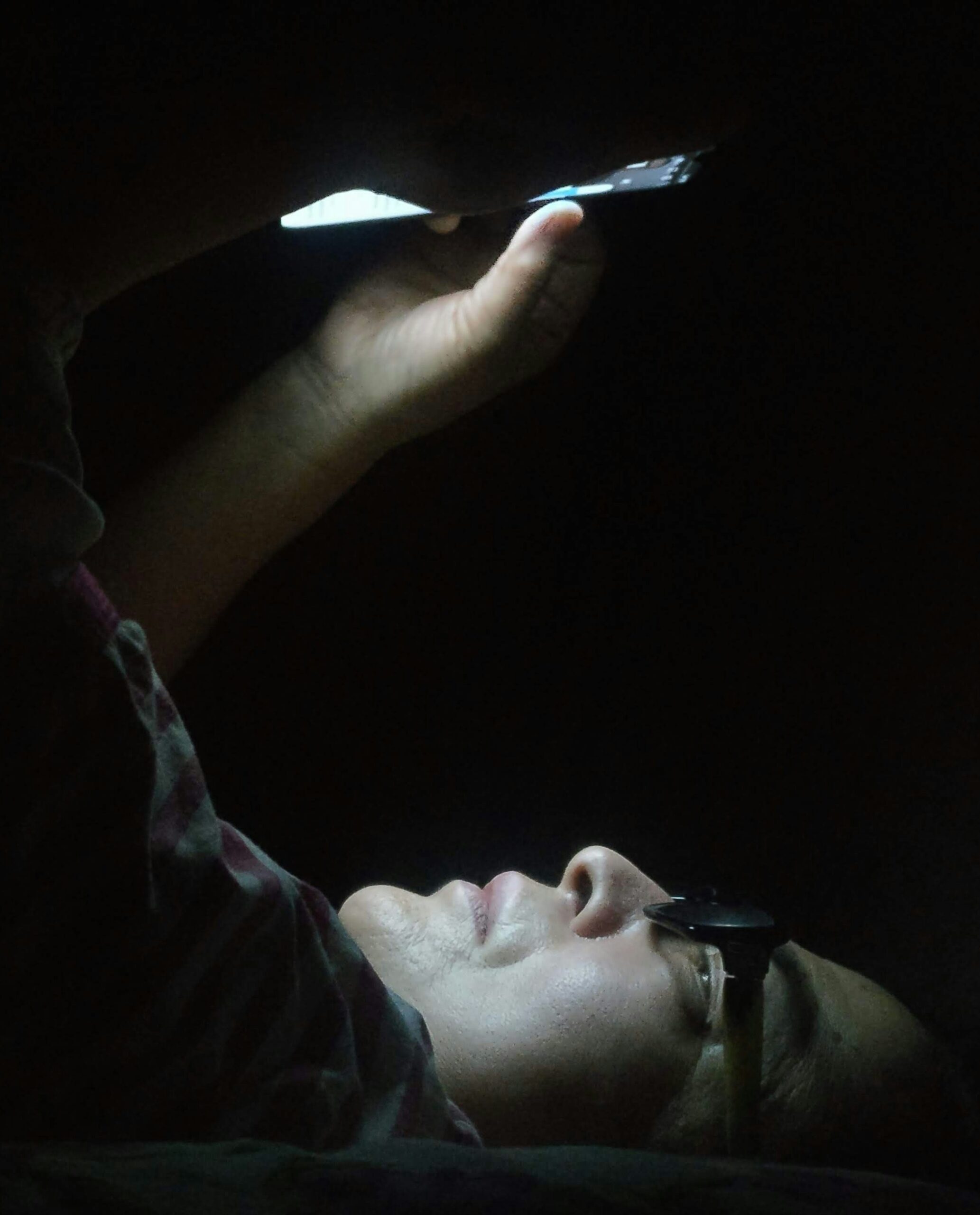 Man looking at phone in the dark
