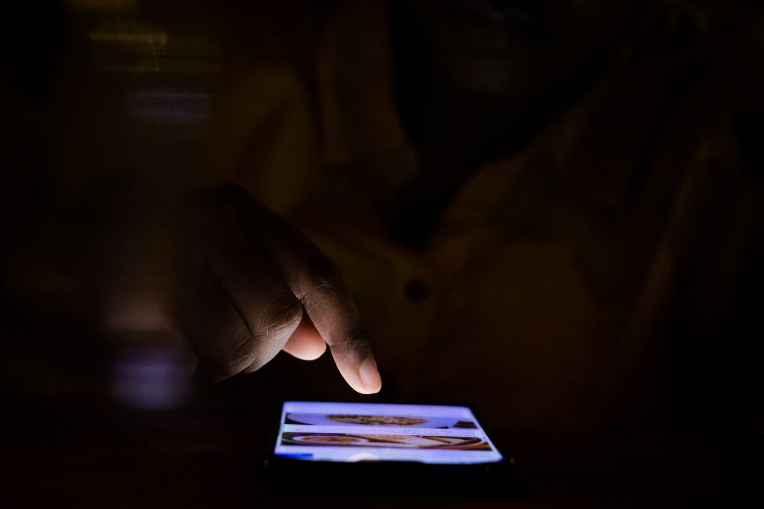 Hand hovering over a glowing smartphone